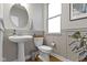 Elegant powder room with a pedestal sink, modern fixtures, and wood flooring at 8245 Bostic Dr, Fishers, IN 46038