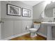 Stylish powder room with wainscoting, pedestal sink, and modern fixtures at 8245 Bostic Dr, Fishers, IN 46038