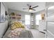 Well-lit bedroom featuring a ceiling fan, shelves with books, and a comfortable-looking bed with decorative pillows at 8245 Bostic Dr, Fishers, IN 46038