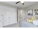 Neutral bedroom showcasing a closet, picture and built-in shelves with a gray bedspread and fun pillows at 8245 Bostic Dr, Fishers, IN 46038