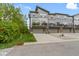 Exterior view of modern townhomes with individual garage doors and private decks overlooking green space at 8245 Bostic Dr, Fishers, IN 46038