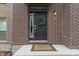 Inviting front door with wreath, brick surround, and 