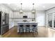Bright kitchen featuring white cabinets, stainless steel appliances, an island with seating and modern pendant lights at 8245 Bostic Dr, Fishers, IN 46038