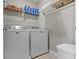 Laundry room with newer white washer and dryer, a shelf for supplies and light tile floor at 8245 Bostic Dr, Fishers, IN 46038
