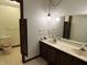 Bathroom with a toilet and a double vanity featuring a dated light fixture above at 830 Millerwood Dr, Lebanon, IN 46052