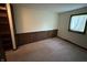 Cozy bedroom with wood paneling, neutral carpet, built-in shelving and a window letting in plenty of natural light at 830 Millerwood Dr, Lebanon, IN 46052