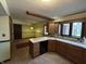 Well-lit kitchen with wooden cabinetry, laminate countertops, and view to eat-in dining area at 830 Millerwood Dr, Lebanon, IN 46052