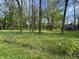 Wide open green spaces are framed by a wire fence and large trees at 830 Millerwood Dr, Lebanon, IN 46052