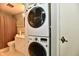 Bathroom featuring stacked washer and dryer units, vanity, and tiled shower at 8360 Paso Del Norte Ct, Indianapolis, IN 46227