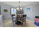 Cozy dining area with a round table, decorative chandelier, and charming window dressings for an intimate setting at 8644 S Tibbs Ave, Indianapolis, IN 46217