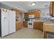Functional kitchen with ample wood cabinetry, white appliances, and a mosaic backsplash, offering a practical cooking space at 8644 S Tibbs Ave, Indianapolis, IN 46217