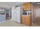 Open kitchen area with a white refrigerator, wooden cabinets, and convenient access to the adjacent dining space at 8644 S Tibbs Ave, Indianapolis, IN 46217