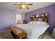 Serene bedroom adorned with purple walls, a plush bed, and a view into the ensuite bathroom, offering a peaceful retreat at 8644 S Tibbs Ave, Indianapolis, IN 46217