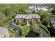Aerial view of stately brick building with mature trees, parking, and a pond at 8751 Jaffa Court East Dr # Apt 32, Indianapolis, IN 46260