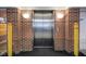 Clean elevator with brick surround and yellow safety bollards, providing easy access to all floors at 8751 Jaffa Court East Dr # Apt 32, Indianapolis, IN 46260