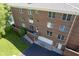 Brick building featuring garage and balcony entrances surrounded by trees and lawns at 8751 Jaffa Court East Dr # Apt 32, Indianapolis, IN 46260