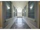 Elegant hallway featuring tiled floors, wainscoting, lighting, and a view of an arched window at 8751 Jaffa Court East Dr # Apt 32, Indianapolis, IN 46260