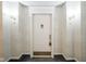 Hallway door with a lion knocker and decorative sconces on the wallpapered wall at 8751 Jaffa Court East Dr # Apt 32, Indianapolis, IN 46260