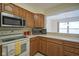 Efficient kitchen space with light countertops and microwave, offering views into the dining area at 8751 Jaffa Court East Dr # Apt 32, Indianapolis, IN 46260