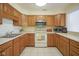 Well-lit kitchen featuring wood cabinetry, white countertops, and essential appliances for cooking and meal prep at 8751 Jaffa Court East Dr # Apt 32, Indianapolis, IN 46260