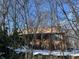 Charming home with wood siding and a quaint front porch, surrounded by bare winter trees and sitting atop a stone foundation at 8803 S Sleepy Hollow Rd, Waldron, IN 46182