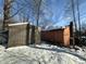 Weathered house with a detached shed in the background, the entire area blanketed in snow at 8803 S Sleepy Hollow Rd, Waldron, IN 46182