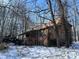 Charming home with wood siding and a quaint front porch, surrounded by bare winter trees and sitting atop a stone foundation at 8803 S Sleepy Hollow Rd, Waldron, IN 46182