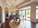 Dining area features a glass table, wrought iron chairs, and hardwood floors, illuminated by natural light from sliding doors at 9789 Rue Renee Ln, McCordsville, IN 46055