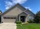 Charming exterior view of home with brick accents, well-maintained lawn, and attached two-car garage at 9789 Rue Renee Ln, McCordsville, IN 46055
