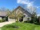 Charming home with stone and siding exterior, well-manicured lawn, and attached two-car garage at 9789 Rue Renee Ln, McCordsville, IN 46055