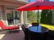 Covered patio features a red umbrella, lounge chairs, and an outdoor dining set, perfect for entertaining at 9789 Rue Renee Ln, McCordsville, IN 46055