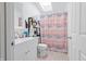 Well-lit bathroom showcasing a modern vanity, toilet, and shower with a colorful curtain at 1000 E Willard St, Muncie, IN 47302