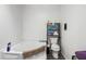 Clean bathroom featuring a large soaking tub, toilet, and shelving unit for convenient storage at 1000 E Willard St, Muncie, IN 47302