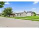 Charming one-story home with a covered porch and mature tree, complemented by the surrounding greenery and blue sky at 1000 E Willard St, Muncie, IN 47302