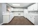 Spacious kitchen features white cabinetry, countertops, and wood-look floors at 10266 Hatherley Way, Fishers, IN 46037