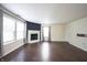 Bright and sunny living room featuring a fireplace, wood-look floors, and multiple windows at 10266 Hatherley Way, Fishers, IN 46037