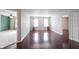 Open living room with hardwood floors, bright windows with curtains, and open doorways at 10266 Hatherley Way, Fishers, IN 46037