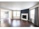 Bright living room featuring a white fireplace with dark wood-look flooring and multiple windows at 10266 Hatherley Way, Fishers, IN 46037