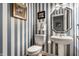 Charming powder room features striped wallpaper and a pedestal sink at 10554 Hyde Park, Carmel, IN 46032