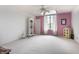 Bright and airy bedroom with neutral walls and carpet, accentuated by a charming arched window and dollhouse at 10554 Hyde Park, Carmel, IN 46032