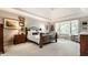 Bright, carpeted primary bedroom featuring tray ceilings and a large window at 10554 Hyde Park, Carmel, IN 46032