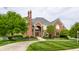 Stunning red brick home with a well-maintained lawn and a circular driveway at 10554 Hyde Park, Carmel, IN 46032