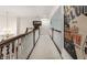 Hallway with a chandelier and dark wood railings, featuring interesting art pieces adding personality to the space at 10554 Hyde Park, Carmel, IN 46032