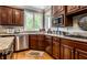 Bright kitchen featuring stainless steel appliances, wood cabinets, and granite countertops at 10554 Hyde Park, Carmel, IN 46032