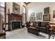 Elegant living room with a fireplace, large window, and leather sofa at 10554 Hyde Park, Carmel, IN 46032