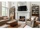 Cozy living room with a fireplace, plush seating, and ample natural light at 10554 Hyde Park, Carmel, IN 46032
