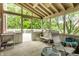 Relaxing screened-in patio features comfortable seating, ceiling fan, and views of the lush backyard at 10554 Hyde Park, Carmel, IN 46032