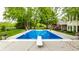 Inviting in-ground pool with diving board surrounded by manicured lawn and mature landscaping at 10554 Hyde Park, Carmel, IN 46032