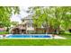 A backyard with an inviting in-ground pool, mature trees, and a lush green lawn at 10554 Hyde Park, Carmel, IN 46032