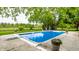 Beautiful in-ground pool, diving board, and large patio surrounded by lush greenery and trees at 10554 Hyde Park, Carmel, IN 46032